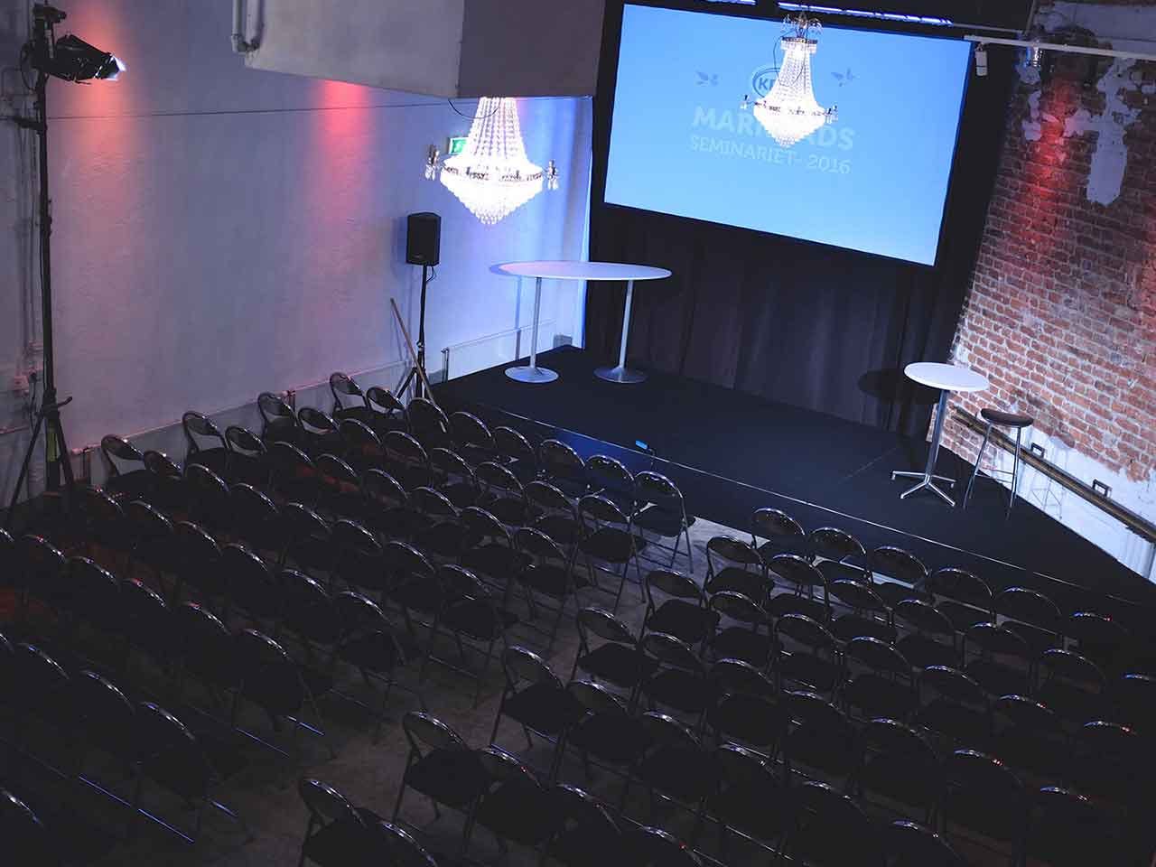 Event space in Tegelrummet with stage, chandelier, ideal for conferences and presentations.