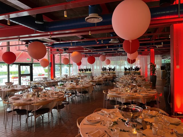 Elegant event space at Patisserie Garnisonen with fine dining setup and festive balloons.
