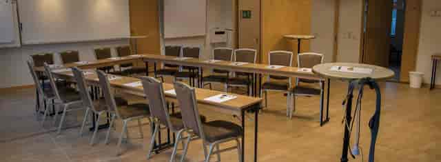 Conference center meeting room with tables for professional gatherings and collaboration.