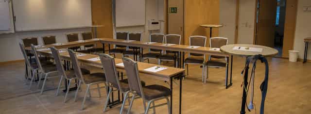 Conference center meeting room with tables for professional gatherings and collaboration.