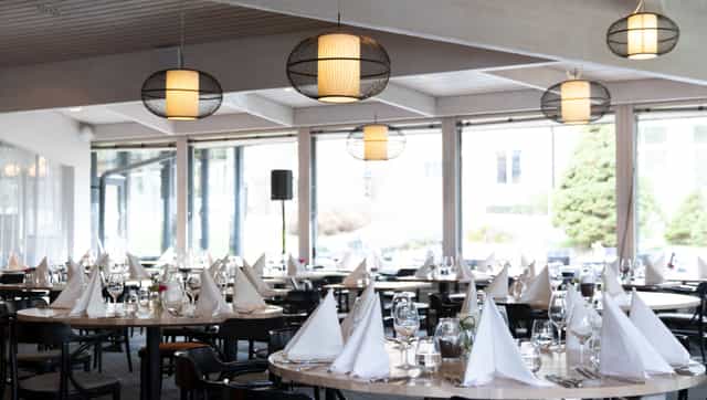 Elegant conference room with set tables, ideal for meetings and events.