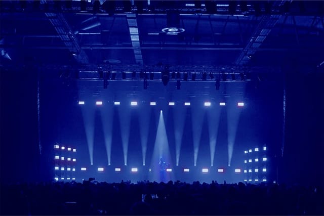 Annexet event space with blue-lit stage for dynamic presentations and performances.