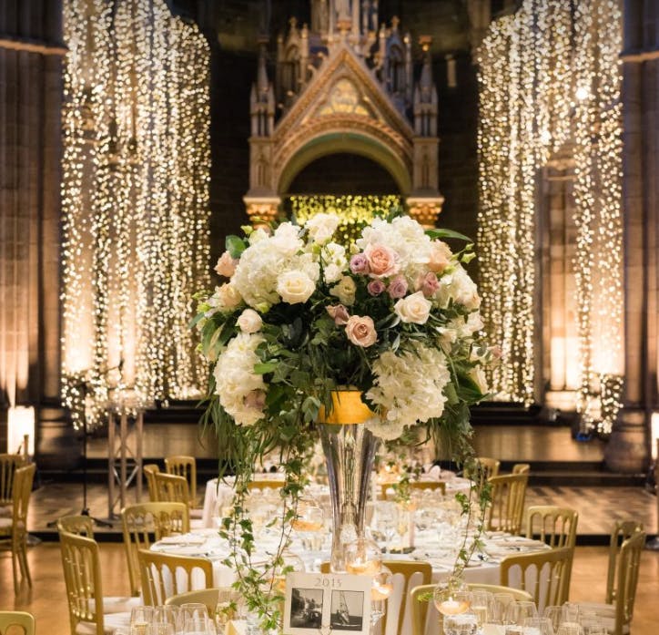 Elegant event space at Headingley Stadium with floral centerpiece and twinkling lights.