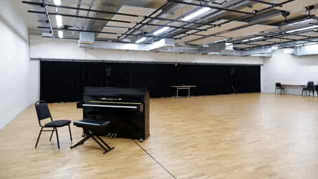 Versatile rehearsal studio with polished wooden floor, ideal for events and performances.