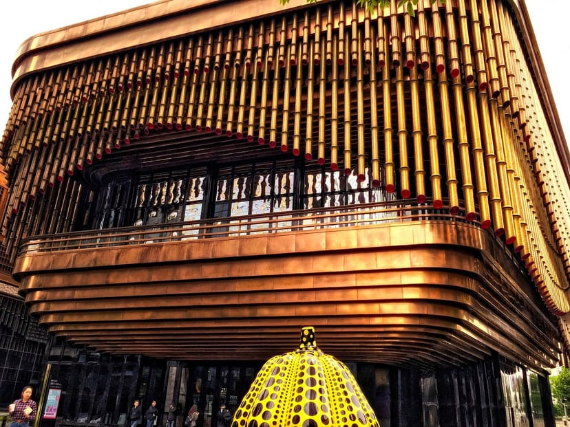 Modern conference center in Fosun Foundation Shanghai with unique wooden facade and vibrant sculpture.