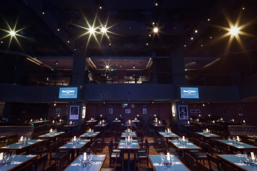 Jazz club event space with blue table settings, perfect for corporate meetings and gatherings.