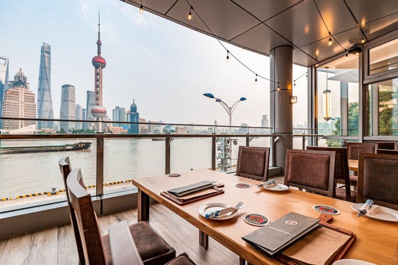 Stylish dining space with skyline view at Paulaner Wirtshaus Shanghai for upscale events.