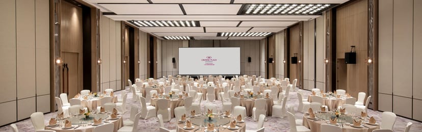Elegant ballroom at W Hotels, set for formal events with round tables and ambient lighting.