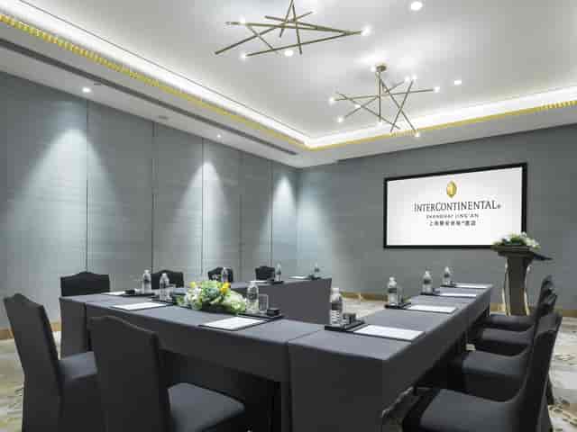 Modern W Hotels meeting room with central table, ideal for corporate events and conferences.