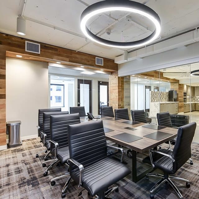 Modern conference room with dark wood table, ideal for corporate meetings and presentations.