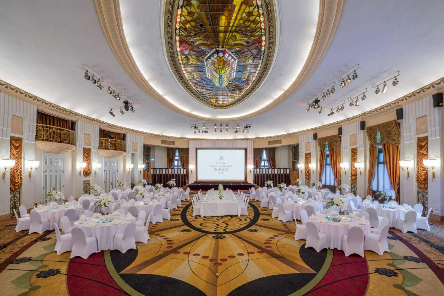 Grand Ballroom at Okura Garden Hotel Shanghai with stained glass ceiling, ideal for conferences.