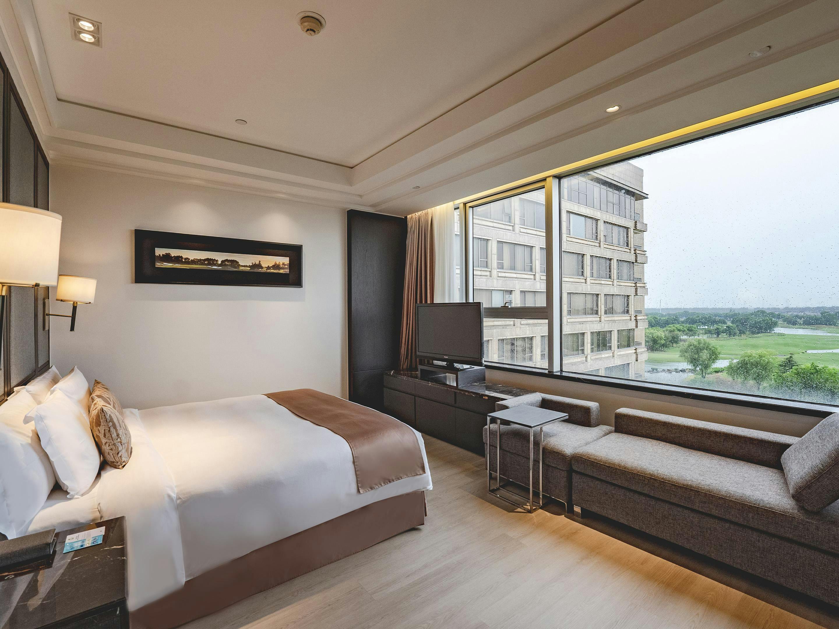 Spacious Crowne Plaza Shanghai hotel room with natural light, ideal for events and meetings.