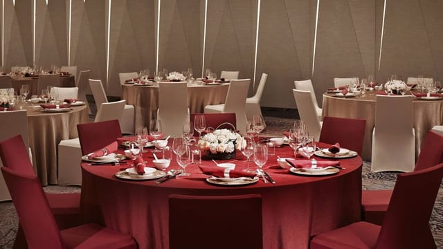 Grand Ballroom at Shanghai Marriott with elegant red tables for corporate events.