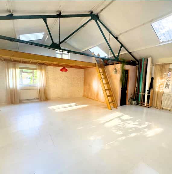 Versatile event space with high ceilings and natural light for workshops and gatherings.
