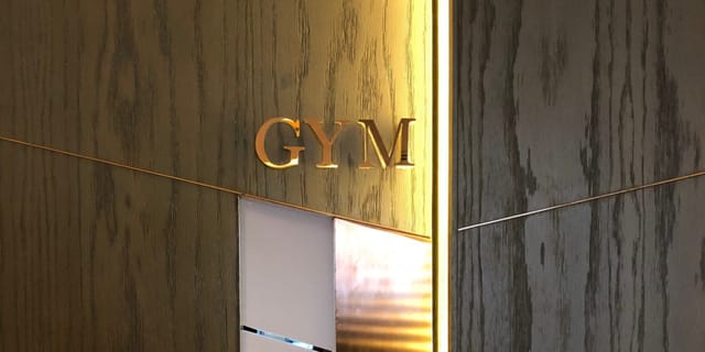 Penthouse Gym entrance at Tower Club Singapore, elegant wood paneling for corporate wellness events.