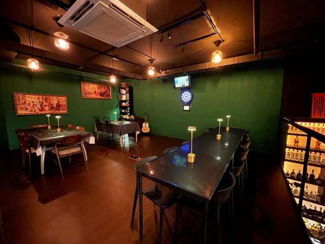 Modern event space at The Velvet Affair, featuring a green accent wall for gatherings.