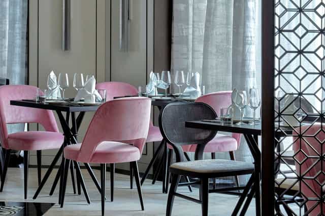 Stylish dining space with pink chairs for corporate events at Tablescape Restaurant, Grand Park.