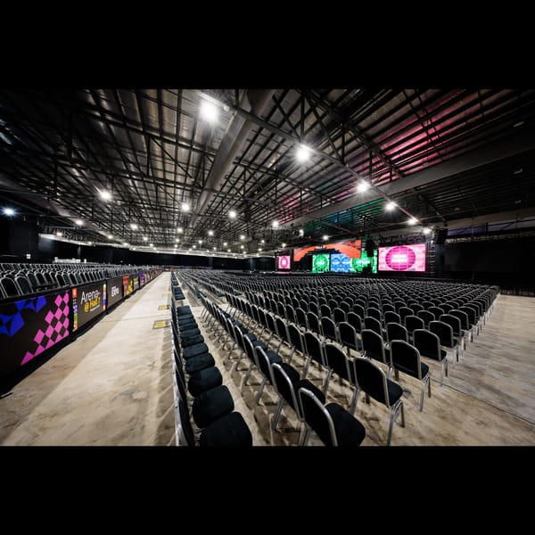 Spacious Arena @ EXPO in Singapore set for a conference with rows of black chairs.