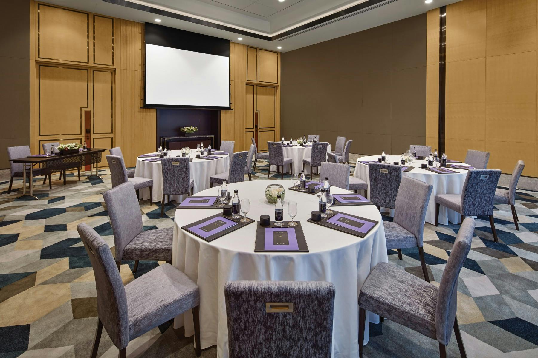 Kapur's meeting room at Sofitel Singapore, ideal for conferences with round tables and modern decor.