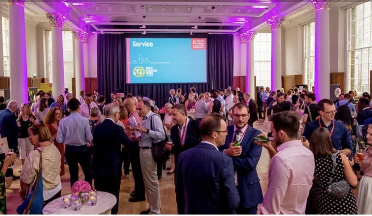 Vibrant networking event at King's College London with elegant purple lighting.