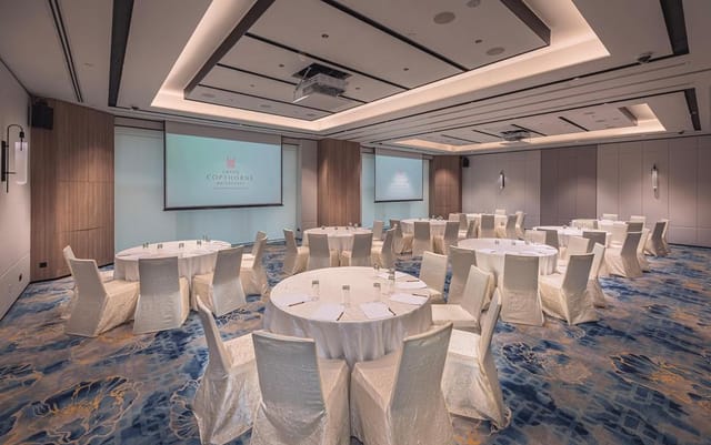 Conference room with round tables, ideal for networking events and workshops.