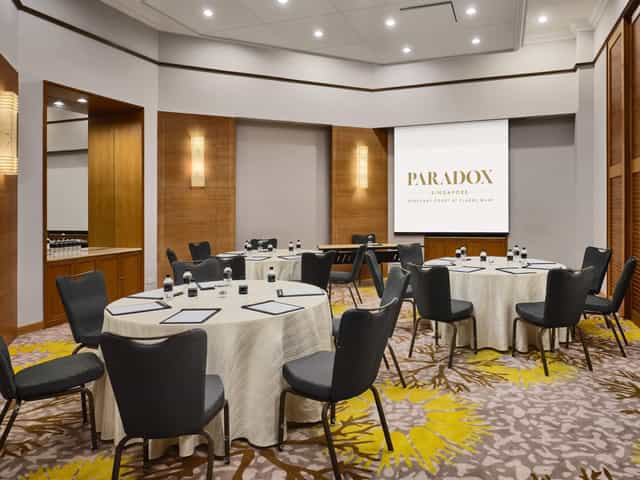 Corporate meeting room at Paradox Singapore, featuring round tables for workshops and seminars.