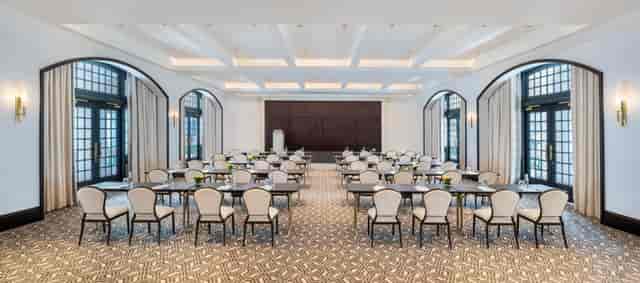 Corporate meeting room at Raffles Hotels, featuring natural light and elegant decor.