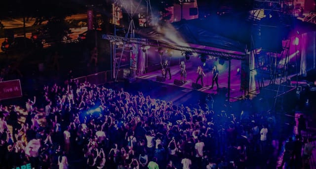 Vibrant outdoor concert at *SCAPE with a large crowd enjoying live music.