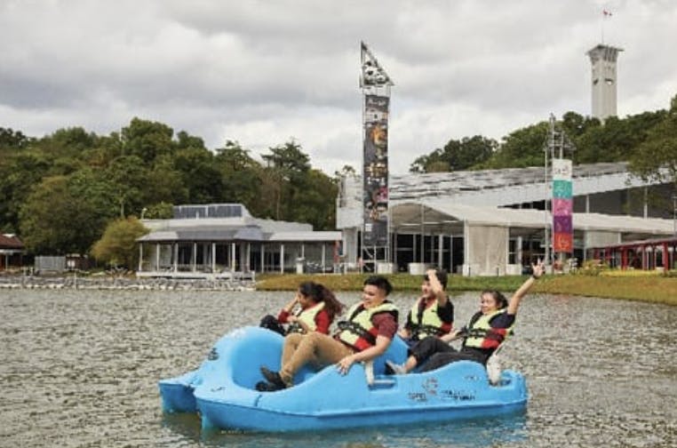 Group on paddle boat at Discovery Land, Singapore, enjoying team-building event.