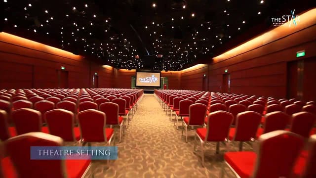 Multi-purpose event hall with red chairs, ideal for conferences and presentations.
