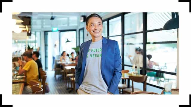 Confident individual in casual professional attire at The Privé Group café for networking events.