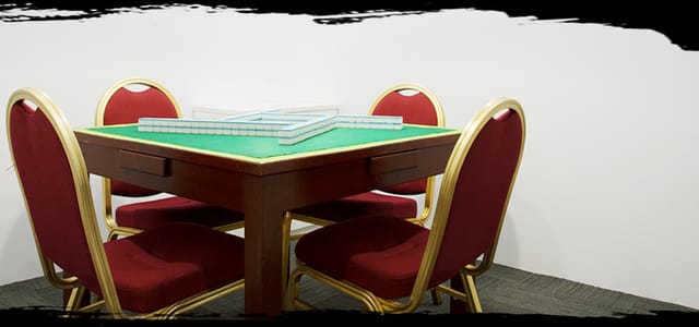 Mahjong Room with green felt table and red chairs for meetings and brainstorming events.
