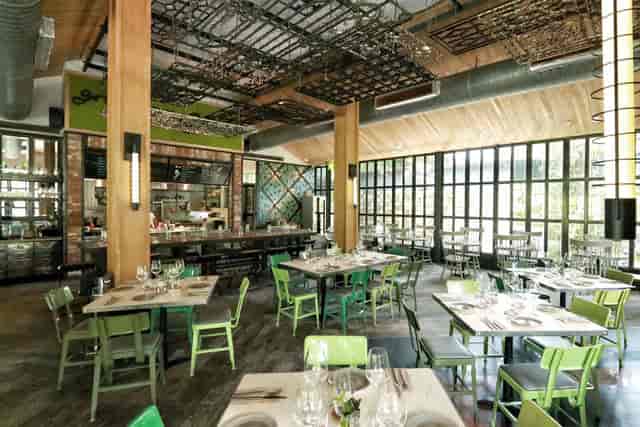 Outdoor garden restaurant with wooden beams, perfect for events and gatherings.