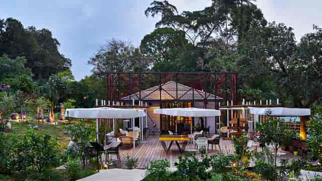 Outdoor cafe venue with lush greenery, ideal for corporate events and celebrations.