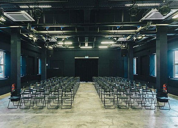 Black Box event space with modern chairs, ideal for presentations and seminars.