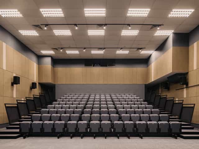 Modern auditorium with tiered seating for conferences and workshops at Common Ground Civic Centre.