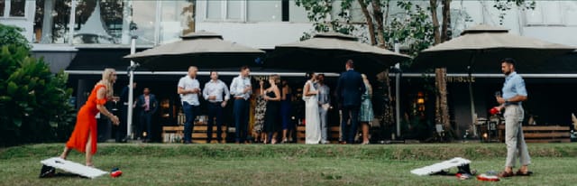 Stylish outdoor event at The Backyard, featuring guests mingling under umbrellas.