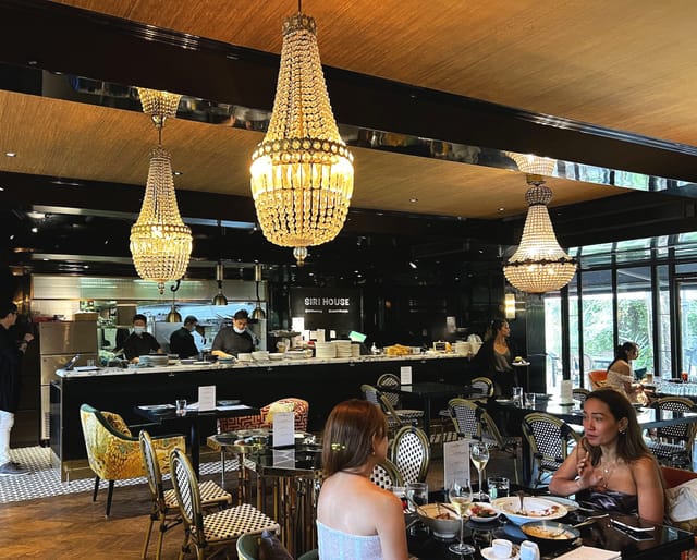 Elegant restaurant lounge with chandeliers, ideal for upscale events and gatherings.