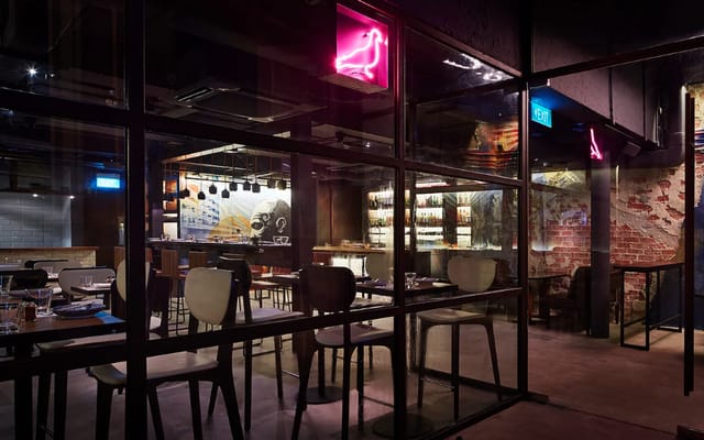 Modern cocktail bar with neon signage, perfect for events and gatherings.