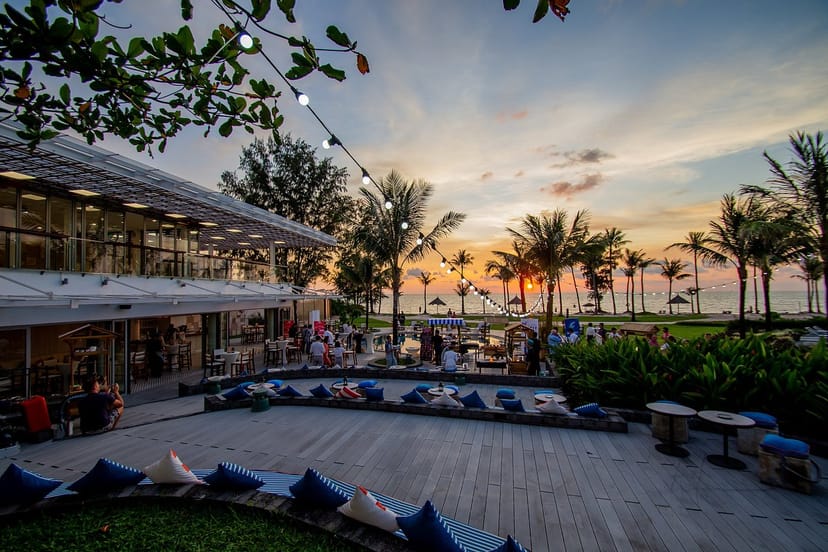 Outdoor bar at Ola Beach Club with sunset backdrop, ideal for events and gatherings.