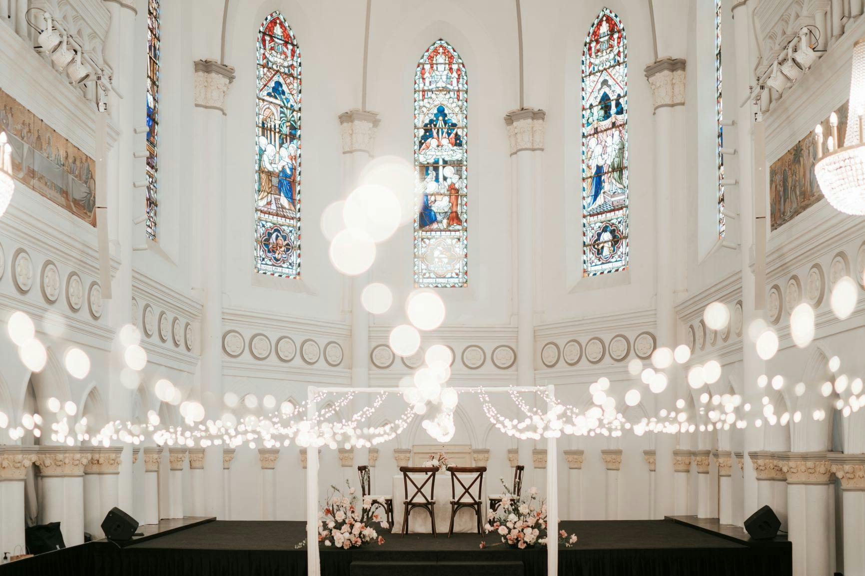 Elegant event space in CHIJMES with stained glass windows, perfect for weddings and gatherings.