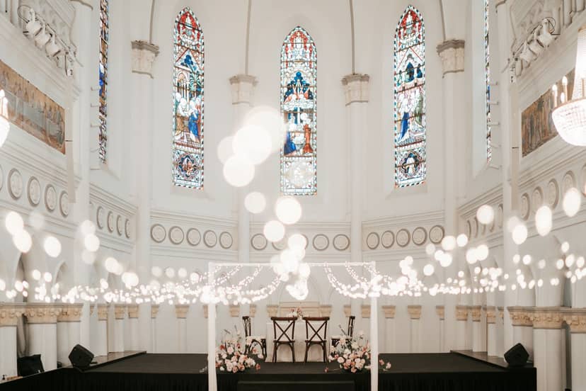 Elegant event space in CHIJMES with stained glass windows, perfect for weddings and gatherings.