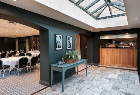 Elegant conference space at The Manor House Hotel with round tables and natural light. - Banner