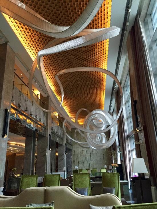 Bar at JW Marriott New Delhi with artistic ceiling, ideal for upscale events and networking.