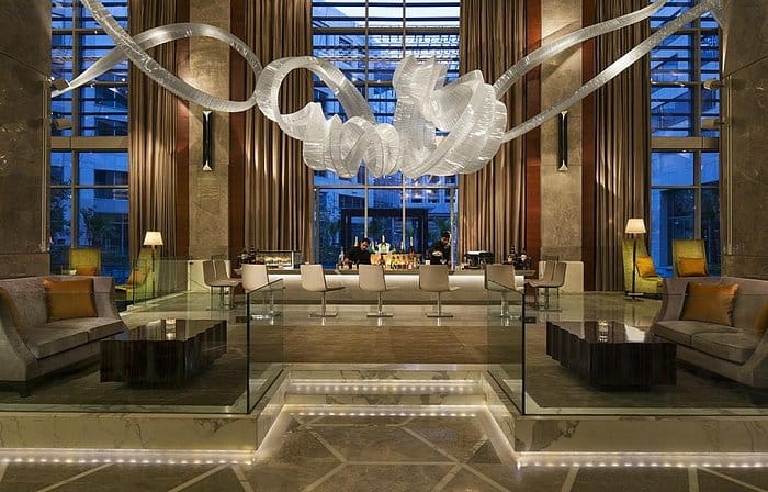 Sophisticated bar at JW Marriott New Delhi, featuring elegant seating and chandelier for events.