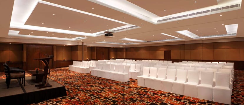 Meeting room with white chairs, ideal for conferences and presentations at DoubleTree Gurgaon.