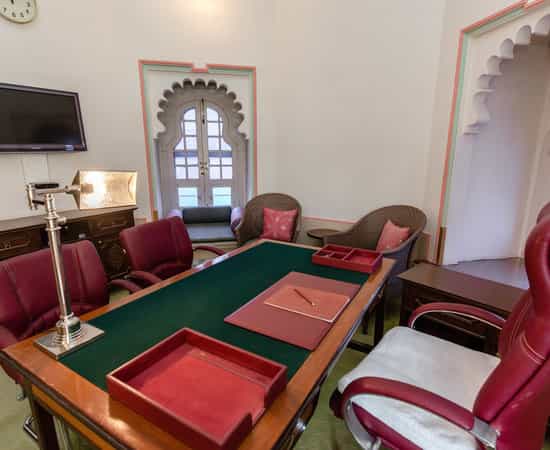 Meeting Room in Fateh Prakash Palace with burgundy chairs, ideal for workshops and meetings.