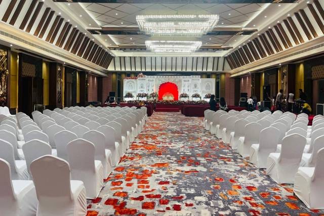 Spacious conference hall with elegant stage, ideal for corporate events and weddings.