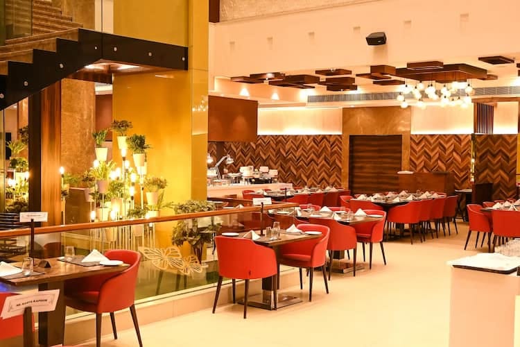 Modern dining space with red chairs at Country Inn & Suites for events and gatherings.