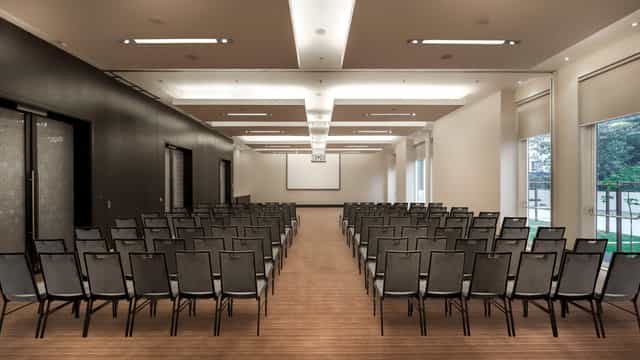 Conference Hall in Udyog Vihar, set up for a seminar with rows of chairs and a blank screen.